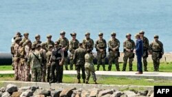 El secretario de Guerra de EE. UU., Pete Hegseth (tercero desde la derecha), saluda a las tropas que participan en el ejercicio militar multinacional Panamax 2026 en Ciudad de Panamá, el 13 de agosto de 2026.  MARTIN BERNETTI / AFP
