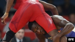 Archivo - El luchador cubano Livan Lopez Azcuy (rojo) se enfrenta al canadiense Haislan Veranes Garcia (azul) durante un combate de la lucha libre olímpica.