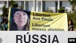 Simpatizantes del grupo ecologista Greenpeace sostienen pancarta con una imagen de la activista brasileña Ana Paula durante una protesta frente a la embajada de Rusia en Brasilia (Brasil).
