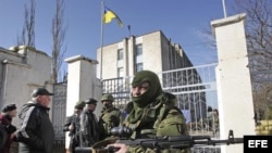 Un soldado armado sin identificar, presuntamente ruso bloquea la entrada a la base naval ucraniana de Novoozerniy, cerca de Feodosia, a las afueras de Simferópol, en la península ucraniana de Crimea.