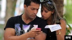 Dos jóvenes usan un teléfono móvil en La Habana. (Archivo)