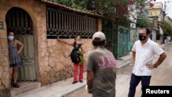 Un estudiante de medicina pide a los vecinos de un barrio de La Habana que se vacunen contra el COVID-19. REUTERS/Alexandre Meneghini