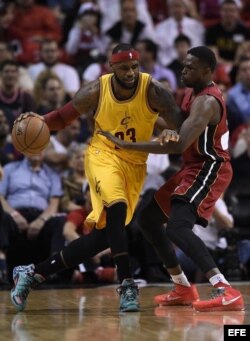 LeBron James (i) de los Cleveland Cavaliers en acción ante Luol Deng (d) de los Miami Heat.