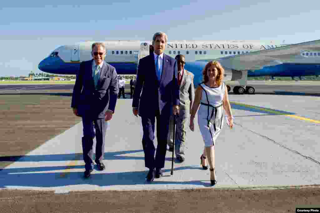 Kerry camina junto a la subdirectora de protocolo del Ministerio de Relaciones Exteriores de Cuba, Lydia González Navarro, y Jeffrey DeLaurentis, encargado de negocios de la embajada estadounidense.