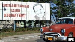 Un vehículo pasa frente a una valla con la imagen del presidente de Venezuela, Hugo Chávez, en La Habana.