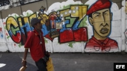  Transeúntes caminan frente a pintadas de apoyo al presidente Hugo Chávez, en el centro de Caracas, Venezuela