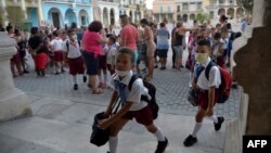 Alumnos cubanos, en una foto tomada en marzo en La Habana al inicio de la pandemia, usan máscaras para evitar el contagio del coronavirus (Archivo/Yamil Lage/AFP).