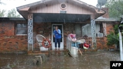 Una mujer pide ayuda con su celular desde su residencia inundada por las lluvias del huracán Florence en Lumberton, Carolina del Norte,