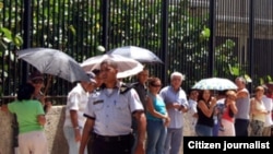 Cubanos hacen fila para entrar a la Sección de Intereses de EE.UU. en La Habana.