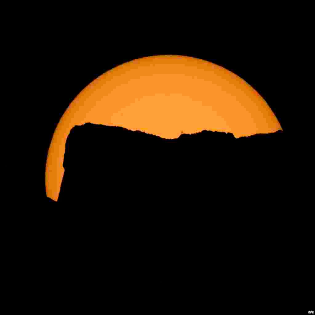 Fotografía cedida por la NASA que muestra una puesta de sol antes del eclipse total en el parque nacional Northern Cascades en Washington.