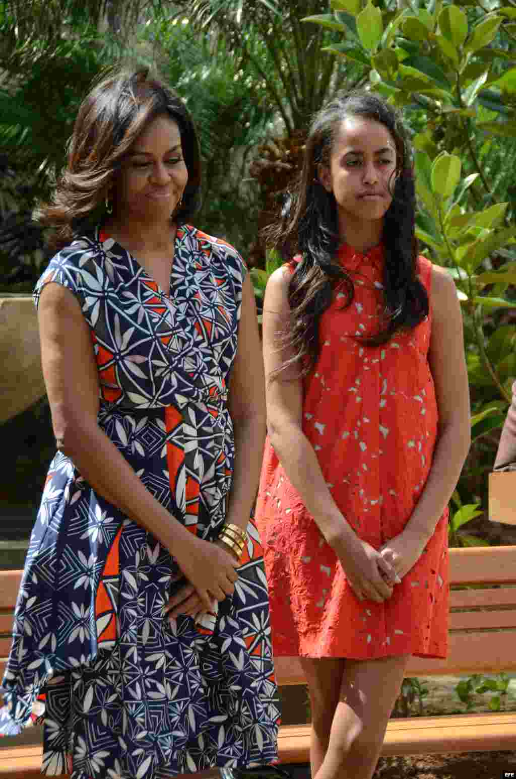 La primera dama estadounidense, Michelle Obama (i), y su hija Malia (d) posan durante una ceremonia hoy, martes 22 de marzo de 2016, en la que donaron y sembraron dos árboles de magnolia, similares a los que florecen en los jardines de la Casa Blanca y un