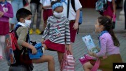 Niños usan máscaras en La Habana, Cuba, donde las autoridades no han decretado un cese de las actividades escolares antes el coronavirus. 