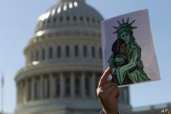 Un activista muestra una imagen a favor de los refugiados durante una manifestación frente al Capitolio de los EE. UU. En Washington, el 15 de octubre de 2019. Foto: AP /Jose Luis Magana.