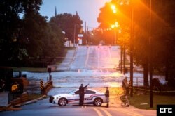 Un policía conversa con un residente mientras las inundaciones causadas por Florence comienzan a descender en Fayetteville.