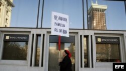 Un hombre protesta ante la sede del Banco de Madrid intervenido por el Banco de España.