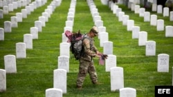 Soldados depositan banderas americanas en cada lápida durante una ceremonia por el Día de los caídos, en el Cementerio Nacional de Arlington, en Virginia.