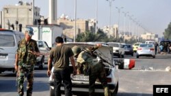 Fotografía cedida por la agencia siria de noticias SANA hoy, miércoles 1 de agosto de 2012, que muestra a dos soldados que inspeccionan un vehículo en un punto de control de Damasco, Siria. 