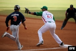 Foto de archivo. El venezolano Henry Rodríguez (i), trata de llegar a primera base ante la defensa del cubano Bárbaro Cañizares (d).