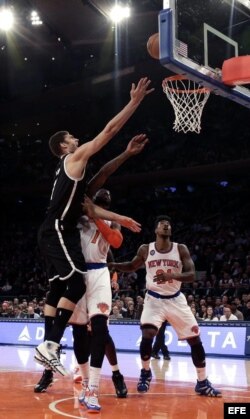 Brook López (i), de los Nets de Brooklyn, intenta anotar ante Iman Shumpertlos y Amar'e Stoudemire (c), de los Knicks de Nueva York.