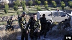 Soldados vigilan la zona donde aparecieron los cuerpos sin vida de los tres jóvenes israelíes en Hebrón (Palestina).