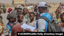 Un trabajador de la ONU en Chad habla con refugiados recién llegados de Sudán.