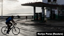 Un cubano pedalea frente a una gasolinera vacía en La Habana tras alza de combustibles en dólares. Foto: REUTERS/Norlys Perez