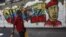  Transeúntes caminan frente a pintadas de apoyo al presidente Hugo Chávez, en el centro de Caracas, Venezuela