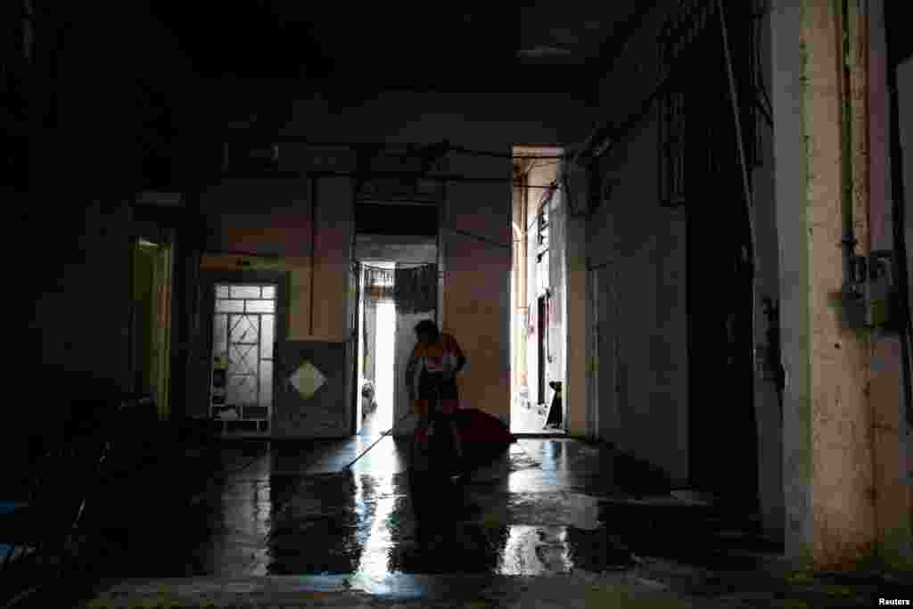 Una mujer limpia frente a su apartamento en un edificio multifamiliar, mientras Cuba se esfuerza por reconectar su red eléctrica nacional tras un apagón generalizado, en La Habana, Cuba, el 4 de agosto de 2026. REUTERS/Norlys Perez