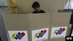 Miembros de mesa y testigos electorales trabajan  durante los preparativos de un centro electoral en Caracas, de cara a las elecciones presidenciales de mañana domingo 14 de abril en Venezuela