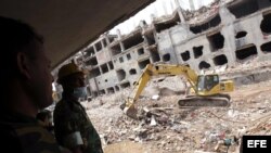 Una grúa limpia los escombros de la fábrica textil derrumbada en la localidad de Dacca, Bangladesh. 