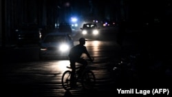 Un cubano recorre en bicicleta las calles oscuras de La Habana en nuevo colapso eléctrico este 1 de agosto 2026. Foto: Yamil Lage / AFP