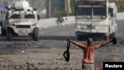 Un manifestante frente a las tanquetas de la guardia nacional durante las protestas en Caracas.