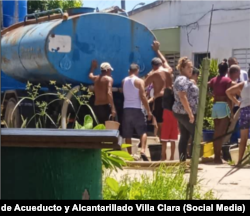 Vecinos de Caibarién esperan para llenar sus envases con agua de una pipa.