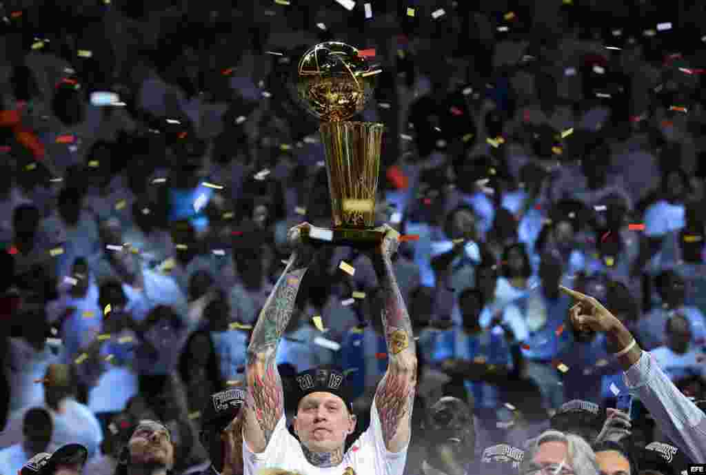 Chris Anderson de los Heat levanta el trofeo de campeón de la NBA. 