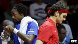 Roger Federer (d) pasa por delante del francés Gael Monfils durante su partido de la final de la Copa Davis entre Francia y Suiza.
