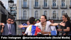 María Corina Machado se acerca a niño presente en concentración de venezolanos en España. 