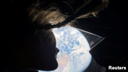 La astronauta Christina Koch observa la tierra desde una ventanilla de la cápsula Orión.