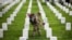 Soldados depositan banderas americanas en cada lápida durante una ceremonia por el Día de los caídos, en el Cementerio Nacional de Arlington, en Virginia.