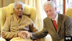 Un fotografía facilitada hoy martes 17 de julio de 2012 muestra al expresiente de Sudáfrica y Premio Nobel de la Paz Nelson Mandela (i) saluda a Bill Clinton (d) despúes de la visita del expresidente norteamericano con motivo del 94º cumpleaños de Mandela
