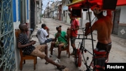 Residentes esperan el restablecimiento del servicio eléctrico en una calle de La Habana, el 17 de marzo de 2026. (REUTERS/Norlys Perez)
