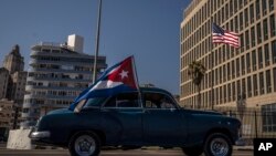 Foto Archivo. Un carro con la bandera cubana pasa frente a la Embajada de Estados Unidos en Cuba. 