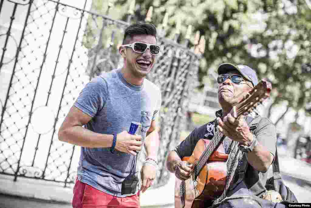 Un músico callejero entretiene al saltador Jonathan Paredes.