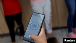 Migrantes utilizan la aplicación CBP One en el albergue Senda de Vida, en Reynosa, México, en mayo de 2023.