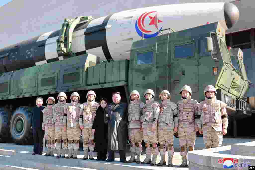 Kim Jong Un (centro a la derecha) y su hija (centro a la izquierda) posando con soldados que contribuyeron a la prueba de fuego del nuevo misil balístico intercontinental. (Foto: KCNA VIA KNS / AFP)