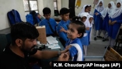 Un niño recibe una dosis de la vacuna de Pfizer BioNTech contra COVID-19 en la escuela en Lahore (Pakistán) el 19 de septiembre de 2022. (© K.M. Chaudary/AP Images)