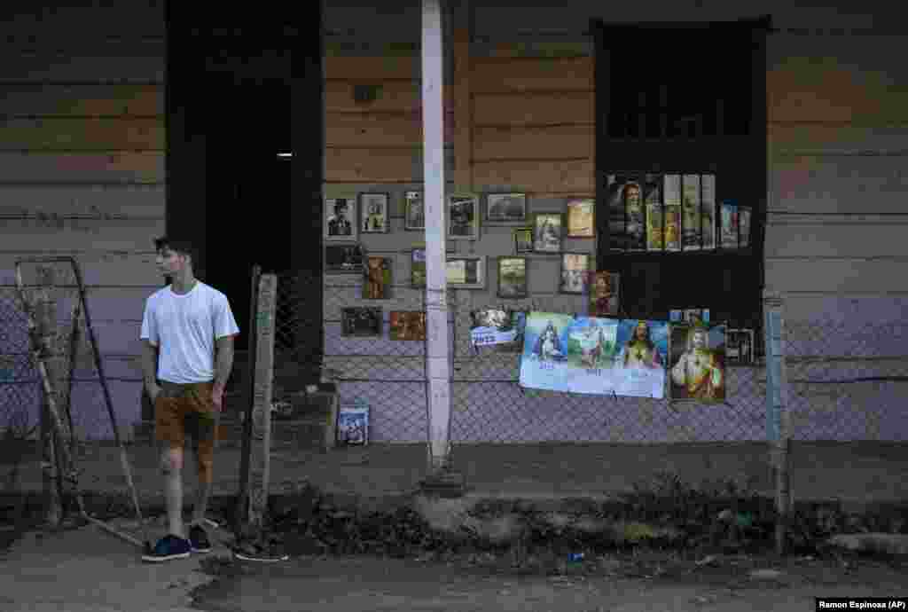 Un vendedor de estampillas espera por los devotos de Sán Lázaro que acuden a la peregrinación al Ricón, en Santiago de las Vegas, en la víspera del 17 de diciembre. (AP/Ramon Espinosa)