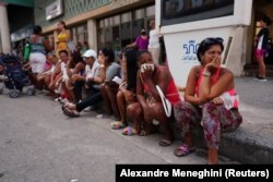 Un grupo de personas espera en una cola para comprar alimentos en una tienda de La Habana Vieja, en la capital cubana, el 3 de octubre de 2022.
