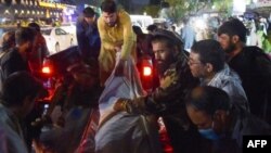 Médicos y voluntarios trasladan cuerpos al hospital tras las dos explosiones en aeropuesto de Kabul (Foto Wakil KOSHAR)