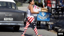 Una joven cubana con la imagen de la bandera de EEUU en su pantalón camina por una calle habanera. EFE