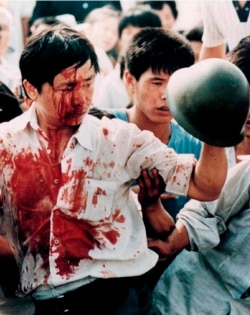 Un manifestante herido sostiene el casco de un militar en la Plaza de Tiananmen el 4 de junio de 1989 (Archivo/Shunsuke Akatsuka/Reuters).